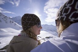 Junges Paar sitzt neben der Skipiste, Kühtai, Tirol, Österreich