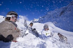 Young people having fun with snowball fight, sitting on snow, Kuehtai, Tyrol, Austria