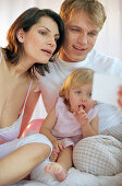 Young family sitting on bed reading a message