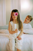 Girl with Gerbera on bed with father, portrait
