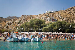 Boats at bank of the peopled Super Paradise Beach, knowing as a centrum of gays and nudism, Psarou, Mykonos, Greece
