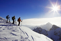 Drei Skifahrer bewundern die Aussicht vom Titlis auf einige Berggipfel. Titlis, Zentralschweiz, Schweiz, Alpen, Europa, MR