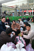 Shanghai Railway Station,Passagiere warten, Kartenspielen, zwischen Koffer und Gepaeck, Passengers waiting, play cards, Gepäck, Bahnhofsvorplatz