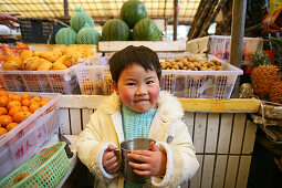 young child with mug at market stand, Shanghai
