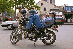 Traffic Shanghai,motorbike taxi, driver, courier, relaxed, lunch break, helmet, street junction