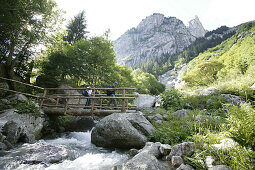 Wanderer gehen über Holzbrücke, Val di Mello Pizzo Cacciabello, Brengalia Mountains, Italy