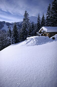 Alpine Skihütte im Schnee mit den Hohen Salve im Hintergrund, Brixen im Thale, Alpen Tirol, Österreich