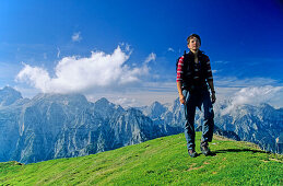 Frau wandert auf einer alpinen Wiese, auf  dem Gipfel des Debela Pec, Triglav Nationalpark, Julische Alpen, im Hintergrund der Triglav Gipfel, Slowenien, Alpen.MR