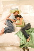 Zwei Mädchen (14-16) liegen auf dem Bett, ein Mädchen mit MP3 Player