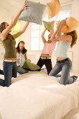 Teenage girls (14-16) having pillow fight