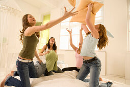 Teenage girls (14-16) having pillow fight