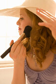 Teenage girl (14-16) applying make-up, sideview