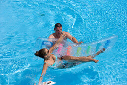 Man throwing woman from air mattress, Apulia, Italy
