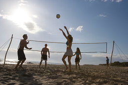 Young people playing beach volleyball, Apulia, Italy