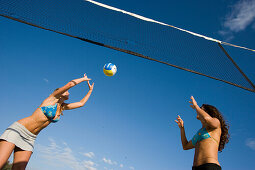 Zwei junge Frauen spielen Beach Volleyball, Apulien, Italien