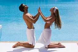 Young couple pressing hands together on poolside, Apulia, Italy
