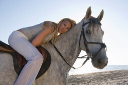 Junge Frau reitet am Strand, Apulien, Italien