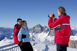 Touristen fotografieren sich vor schneebedeckter Landschaft, Passo Pordoi, Dolomiten, Italien, Europa