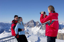 Tourists taking pictures in front of snow covered landscape, Passo Pordoi, Dolomites, Italy, Europe