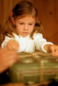 Girl (3-4 years) holding christmas present