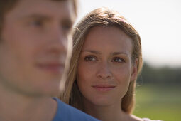 Young couple in nature, woman behind man