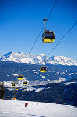 Cabin cable car and skiers on slope Dachstein Mountains at horizon, Flachau, Salzburger Land, Austria