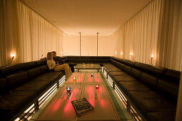 Couple sitting on lounge, tablet pc ins foreground, Vernissage Club, Design by Heinz Julen, Zermatt, Valais, Switzerland