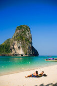 Tourists lying at white sandy beach, overgrown chalk cliff in background, Phra Nang Beach, Laem Phra Nang, Railay, Krabi, Thailand, after the tsunami