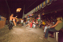 Tourists sitting in a beach bar, man juggling fire pois, Ko Phi Phi Don, Ko Phi Phi Island, Krabi, Thailand, after the tsunami