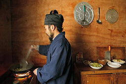 Ein Mönch kocht in der Küche des Klosters Cui Yun Gong, Hua Shan, Provinz Shaanxi, China, Asien