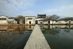 Teich mit Brücke vor den traditionellen Häusern des Dorfes Hongcun, Huangschan, China, Asien