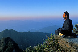 monk meditating in lotus position, sunrise, Golden Hall, Jindian Gong, peak 1613 metres high, Wudang Shan, Taoist mountain, Hubei province, Wudangshan, Mount Wudang, UNESCO world cultural heritage site, birthplace of Tai chi, China, Asia