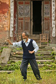 Taichi Meister demonstriert Taiji Zyklus vor seinem alten Haus am Fuß des Wudang Shan, daoistischer Berg in der Provinz Hubei, Geburtsort des Taichi, China, Asien, UNESCO Weltkulturerbe