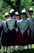 Gruppe von jungen Frauen in Tracht, von hinten, mit Trachtenhüten mit Adlerflaum geschmückt, Trachtenwallfahrt nach Raiten, Chiemgau, Oberbayern, Bayern, Deutschland