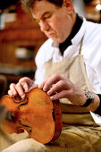 Man reparing a violin, Antique Violin repair shop, Old Town, Prague, Czech Republic