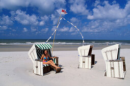 Young woman in beach chair, Wangerooge, North Sea, Germany