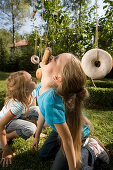 Girls playing donut catching, children's birthday party