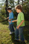 Two boys playing egg-and-spoon race, children's birthday party