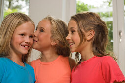 Drei Mädchen stehen nebeneinander und lachen, Kindergeburtstag