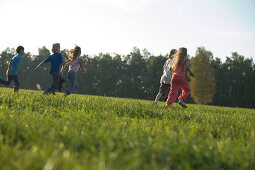 Children running over field, children's birthday party