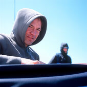 Man wearing a hooded shirt on a sailboat, person in background, portrait, Bay of Kiel between Germany and Denmark