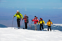 A group of skitourists climb with skis and skins to the top of the Popova Kapa in the Rila Mountains, Europe, Bulgaria, MR