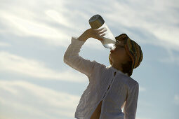 Mädchen trinkt aus einer Flasche Wasser, Travemünder Bucht, Schleswig-Holstein, Deutschland