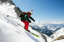 Ein junger Skifahrer, ein Freerider fährt einen Steilhang im Tiefschnee am Säntis, im Hintergrund die Churfirsten, Appenzell, St. Gallen, Toggenburg, Ostschweiz, Schweiz, Alpen