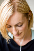 Young woman listening to music about earphones