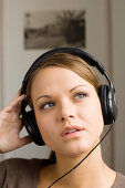 Young woman listening to music about earphones