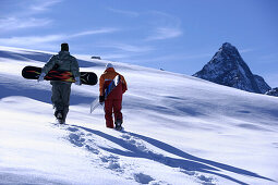 Zwei Snowboarder laufen durch Schnee, Hintertuxer Gletscher, Zillertal, Tirol, Österreich
