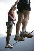 Two men climbing on a rope bridge at Crazy Eddy in Silz, Haiming in the background, Tyrol, Austria