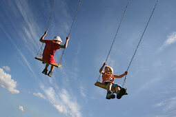 Boy and girl (5-6 years) on a swing
