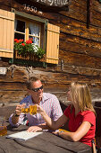 Couple clinking glasses, Lammersdorfer Hut, 1650 m, Lammersdorf near Millstatt, Carinthia, Austria